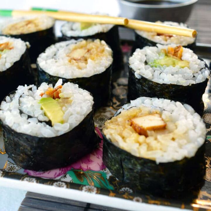 A black tray with sushi on it