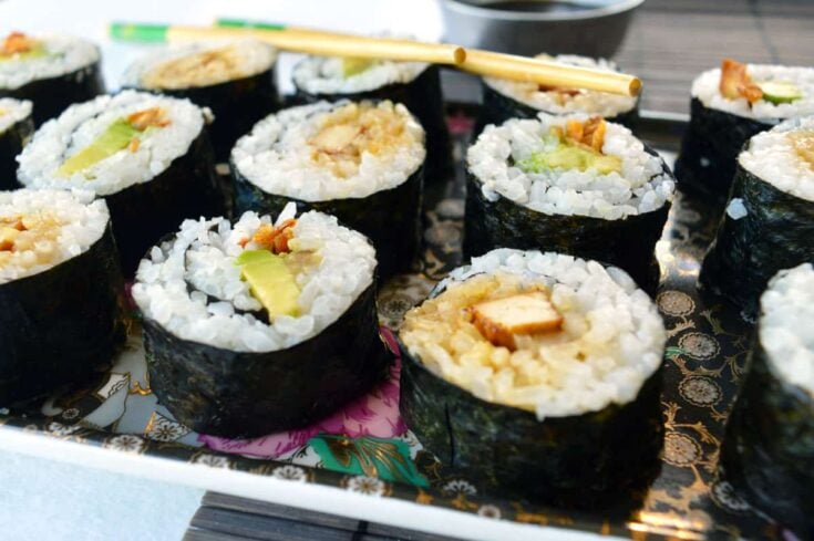 A black tray with sushi on it