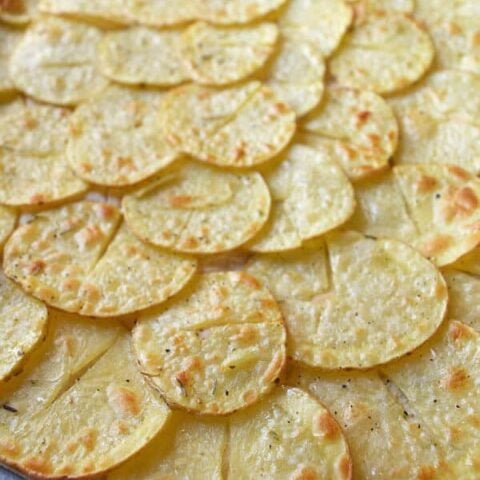 Thin cooked slices of potato on a pizza base