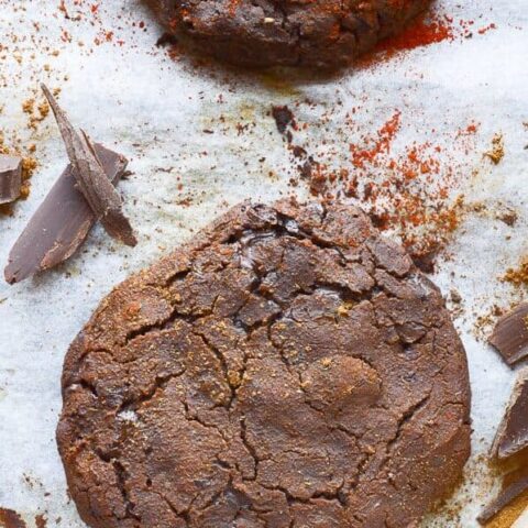 One and a half chocolate cookies with spice powders and chocolate chunks around them and on them