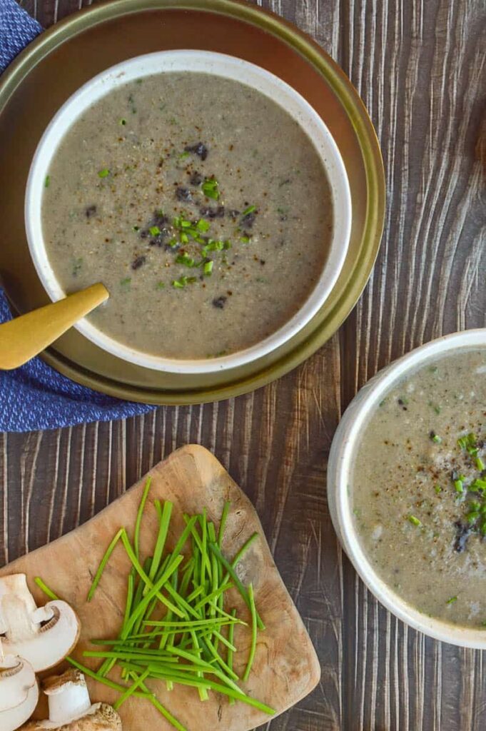 Two bowls of beige soup, one on a gold background