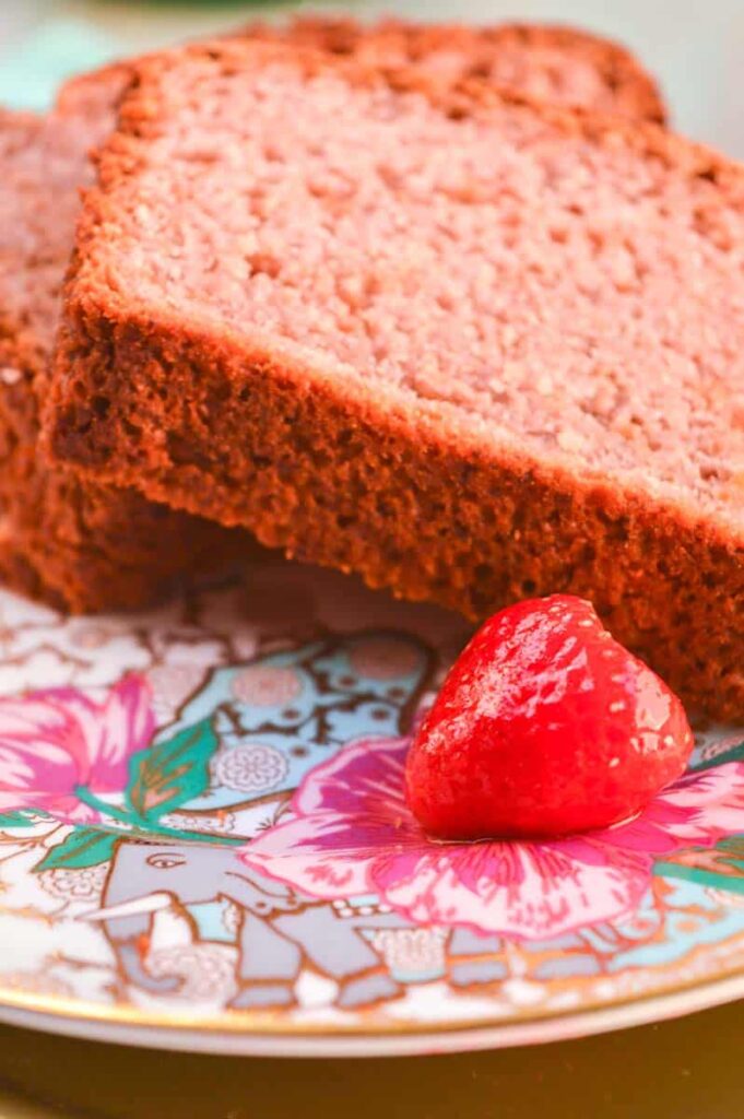 Two slices of strawberry bread and a strawberry