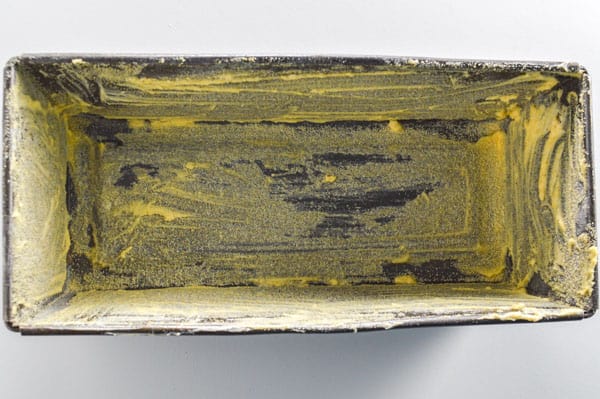 A greased tin with cornmeal sprinkled in it