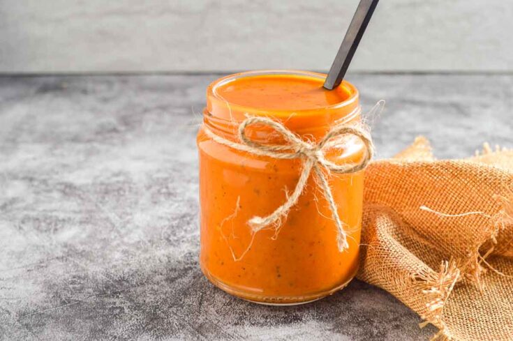A glass jar of orange sauce