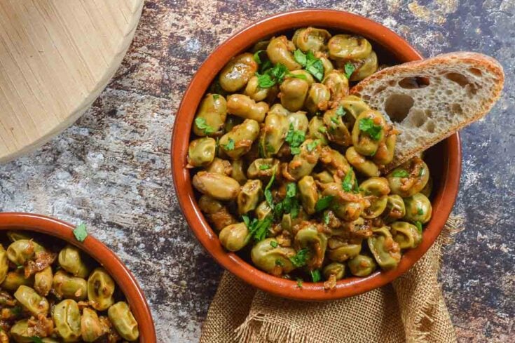 Broad beans in a terracotta tapa dish with bread