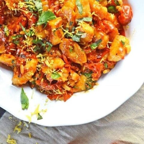Gnocchi coated in cherry tomato sauce with fresh basil sprinkled over