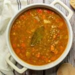A white casserole dish with lentil stew in it.