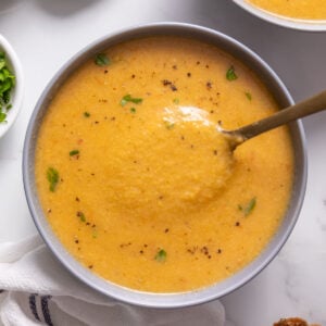 A yellow-orange soup in a grey bowl.
