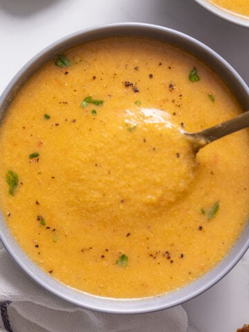 A yellow-orange soup in a grey bowl.