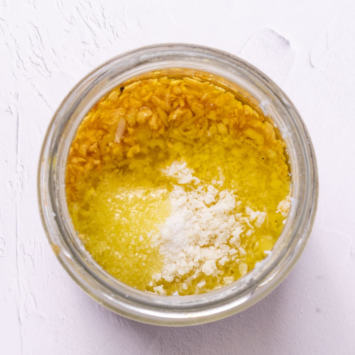 Minced garlic in oil and salt in a glass jar.