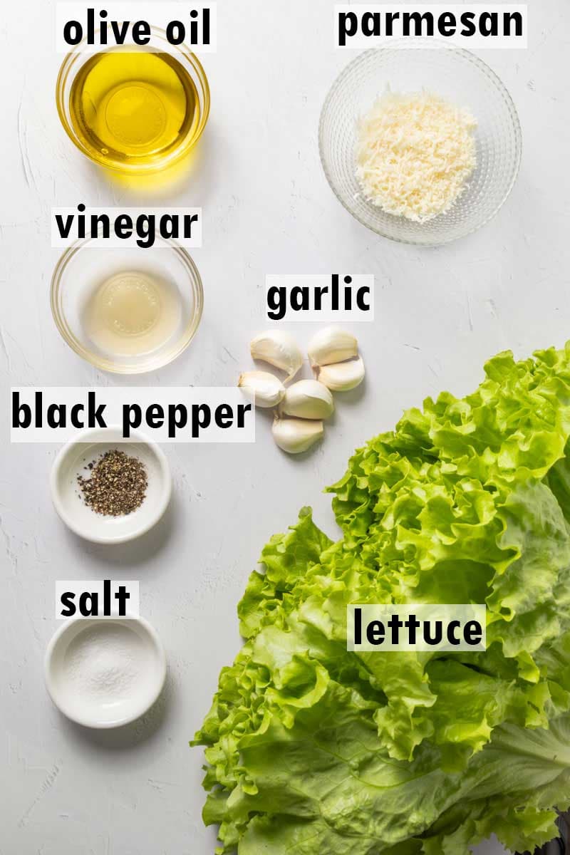 Lablled ingredients including olive oil, parmesan, vinegar, garlic, black pepper, salt and lettuce.